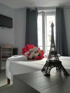 um modelo da torre Eiffel sentada numa cama em Hotel du Globe 18 em Paris
