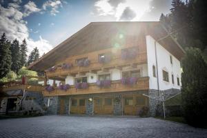 a building with a balcony with flowers on it at Landhaus Maria in Neustift im Stubaital +10 photos