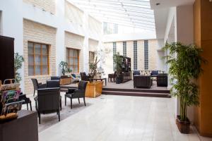 a lobby with chairs and tables in a building at Progress Hotel in Brussels