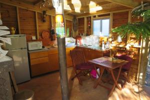 eine Küche mit einem Tisch und einem Kühlschrank in der Unterkunft Un Temps Pour Soi in Bouloupari