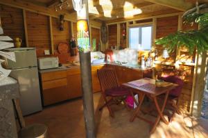 a kitchen with a table and a refrigerator at Un Temps Pour Soi in Bouloupari