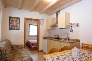 a kitchen with a sink and a table with a counter top at Camping Castelpietra in Fiera di Primiero