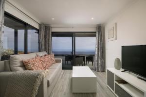 Una sala de estar con un sofá y un televisor de pantalla plana. en ANGEL´S SUNSET, en Estreito da Calheta