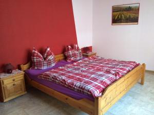 a bedroom with a wooden bed with a red wall at Weingut & Gästehaus Nagel in Kapellen-Drusweiler
