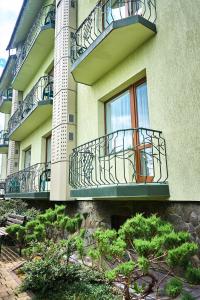 a building with balconies and bushes in front of it at Hermes Resort Hotel Rest and Treatment in Truskavets