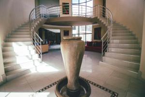 a spiral staircase with a vase in the middle of a room at Castellon Boutique Hotel in Table View