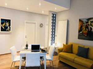 a living room with a couch and a table with a laptop at Marina Apartment & suite in Verbania