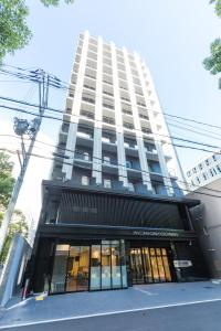 ein hohes weißes Gebäude mit einem Gebäude in der Unterkunft Sanco Inn Osaka Yodoyabashi in Osaka