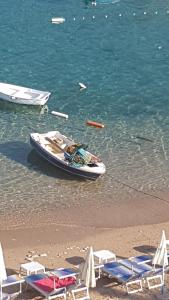 a small boat sitting on the beach with chairs at Pržno Luxury Apartments in Sveti Stefan