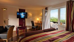 ein Hotelzimmer mit einem Bett und einem TV an der Wand in der Unterkunft Landidyll Hotel Restaurant Birkenhof in Klosterkumbd