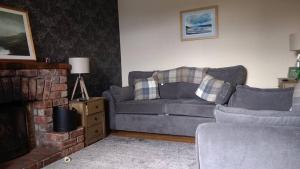 a living room with a couch and a fireplace at George's House - 1 Leacklee in Manish