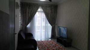 un salon avec une grande fenêtre et une télévision dans l'établissement Kasa Heights Homestay, à Malacca 14 autres photos