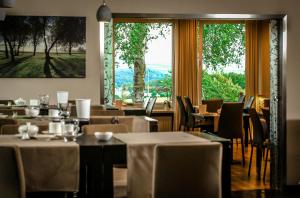 ein Restaurant mit Tischen und Stühlen und einem großen Fenster in der Unterkunft Landidyll Hotel Restaurant Birkenhof in Klosterkumbd