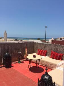 a patio with a couch and a table and the beach at Riad A La Belle Etoile in Salé