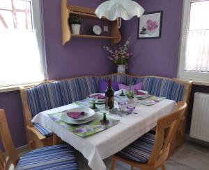 a dining room table with a white table cloth and a bottle of wine at Ferienhaus Agnes in Ramberg +30 photos