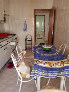 カバナス・デ・タビラにあるappartement cabanas de tavira bord de merのキッチン(テーブル、椅子2脚、テーブル、テーブル付)