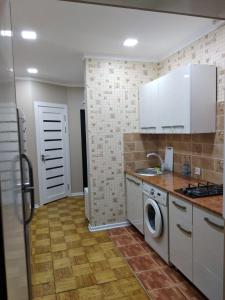 Il comprend une cuisine équipée d'un évier et d'un lave-linge. dans l'établissement Apartment on Oloy 11, à Tachkent