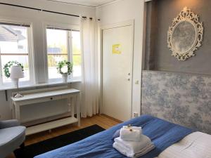 een slaapkamer met een blauw bed en handdoeken bij Spirans Rum och Logi in Trollhättan