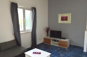 a living room with a tv and a window at Apartments Vuković in Stari Grad