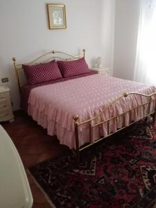 a bedroom with a bed with a pink comforter and a rug at Villa Marina Big in Laterina