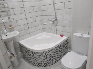 een badkamer met een bad naast een toilet en een wastafel bij Apartment on Oloy 11 in Tasjkent