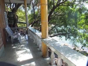 een veranda met een stoel, een paal en bomen bij Queen Resort Koh Tao in Ko Tao