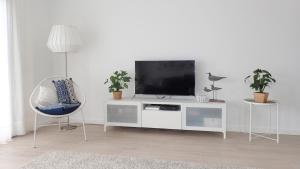 a living room with a tv on a white cabinet at Silver Breezes Apartment in Nazaré
