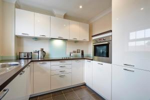 kuchnia z białymi szafkami i zlewem w obiekcie 2 bed 2 bath at Jago Crt in Newbury - FREE allocated parking w mieście Newbury