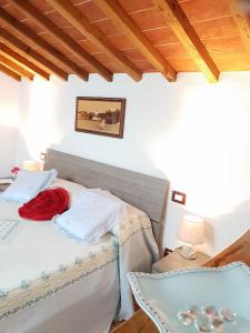 Un dormitorio con una cama con una manta roja. en Mansarda degli Ulivi, en Rigomagno