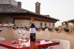 a bottle of wine sitting on a table with two wine glasses at Palazzo Neri in Trevi