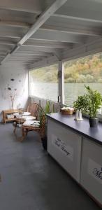 a living room with a table and chairs on a boat at Cafe Sander´s Camping auf der Mosel in Winningen