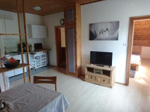 a living room with a tv on a stand with a table at Berliner Ecke in Mariazell