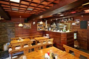 a restaurant with wooden walls and tables and a bar at Penzion U Kotle in Horni Misecky