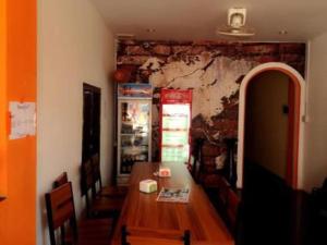 a dining room with a table and a wall at Intouch Guest House in Vientiane