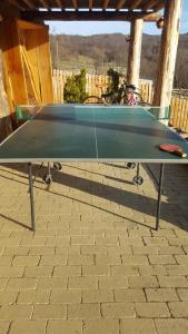 una mesa de ping pong en la parte superior de un suelo de ladrillo en Casuta din Poiana, en Poiana