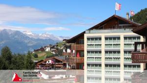 a hotel in the mountains with mountains in the background at Family Hotel & Spa Desirée in Grächen