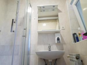 a bathroom with a sink and a shower with a mirror at Apartment Petra in Szlatina +8 photos