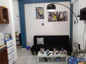 a living room with a black couch and a table at Apollon Apartments H-1 H-2 in Rhodes Town