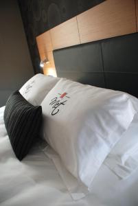 a bed with a white comforter and pillows at Met Boutique Hotel in İzmir