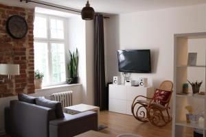 a living room with a couch and a tv at Apartament Przy Katedrze in Toruń