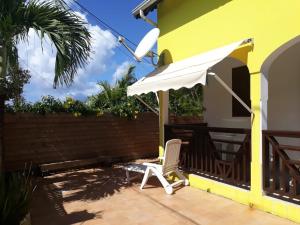 une terrasse avec une chaise et un parasol dans l'établissement location guadeloupe, au Gosier