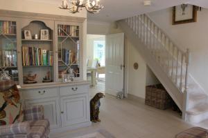 a dog standing in a living room with a staircase at Harlequin B&B Ledbury in Ledbury