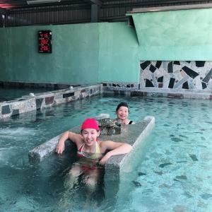 two children are swimming in a swimming pool at San He Inn in Taimali