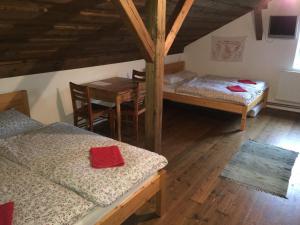 Habitación con 2 camas, mesa, mesa y sillas. en Penzion Olesnice en Zlatá Olešnice