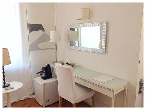 escritorio blanco con espejo y silla blanca en Relais Piazza dei Martiri en Nápoles