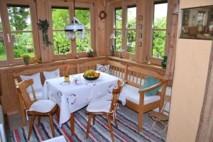 a dining room with a table and chairs and windows at Haus Martina in Siegsdorf