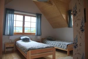 a bedroom with two beds and a window at Ciche Pole in Maniowy