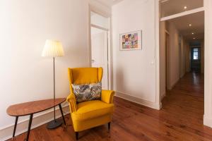 a yellow chair and a table in a room at Lisbon City Center Apartment in Lisbon