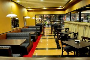 un restaurante con mesas y sillas y un bar en The Orchard Cebu Hotel & Suites, en Cebú