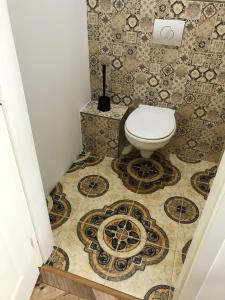 a bathroom with a toilet on a tiled floor at Charming&Luxury - Spacious Apartment in Old Town in Bratislava